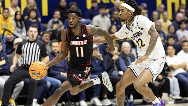 Dec 30, 2025; Berkeley, California, USA; Louisville Cardinals guard Kobe Rodgers (11) drives past California Golden Bears forward Chris Bell (22) during the first half at Haas Pavilion. Mandatory Credit: D. Ross Cameron-Imagn Images