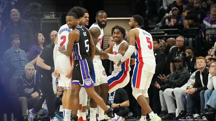 Dec 26, 2024; Sacramento, California, USA; Detroit Pistons guard Jaden Ivey (23) is helped up by teammates after scoring a three point basket and drawing a foul against Sacramento Kings guard De'Aaron Fox (5) during the fourth quarter at Golden 1 Center. Mandatory Credit: Kelley L Cox-Imagn Images