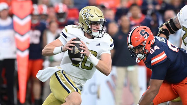 Sep 7, 2024; Syracuse, New York, USA; Georgia Tech Yellow Jackets quarterback Haynes King (10) runs from Syracuse Orange defensive lineman Kevin Jobity Jr. (94) in the first quarter at JMA Wireless Dome. Mandatory Credit: Mark Konezny-Imagn Images