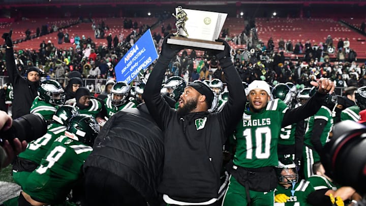 Winslow Township High School's head football coach Bill Belton hoists the trophy and celebrates with his players after Winslow defeated Phillipsburg, 35-0, in the State Group 4 football final played at SHI Stadium at Rutgers University in Piscataway on Wednesday, December 4, 2024.