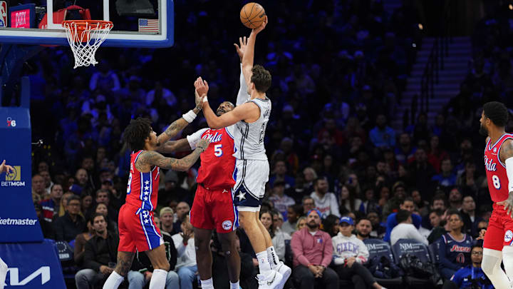 Dec 6, 2024; Philadelphia, Pennsylvania, USA; Orlando Magic forward Franz Wagner (22) shoots the ball against Philadelphia 76ers center Andre Drummond (5) and guard Kelly Oubre Jr (9) in the third quarter at Wells Fargo Center. Mandatory Credit: Kyle Ross-Imagn Images