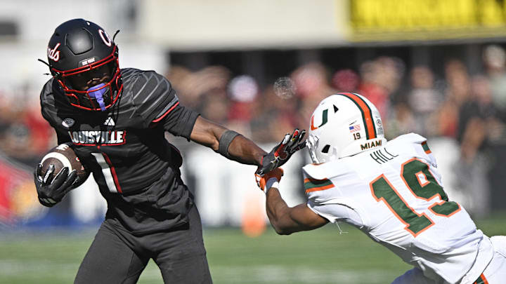 Oct 19, 2024; Louisville, Kentucky, USA; Louisville Cardinals wide receiver Ja'Corey Brooks (1) runs the ball against Miami Hurricanes defensive back D'Yoni Hill (19) during the second half at L&N Federal Credit Union Stadium. Miami defeated Louisville 52-45. Mandatory Credit: Jamie Rhodes-Imagn Images