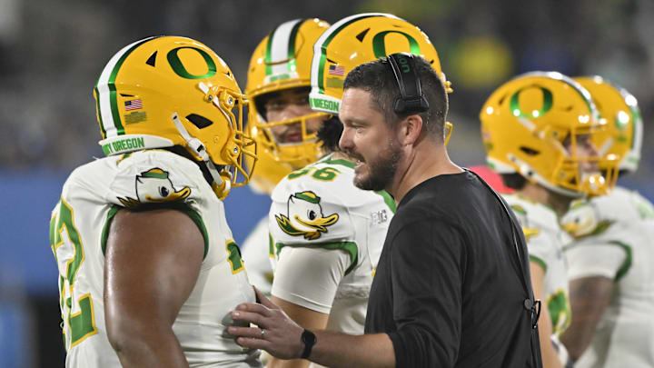 Sep 28, 2024; Pasadena, California, USA; Oregon Ducks head coach Dan Lanning talks to Oregon Ducks offensive lineman Iapani Laloulu (72) during a timeout in the fourth quarter against the UCLA Bruins at Rose Bowl. Mandatory Credit: Robert Hanashiro-Imagn Images