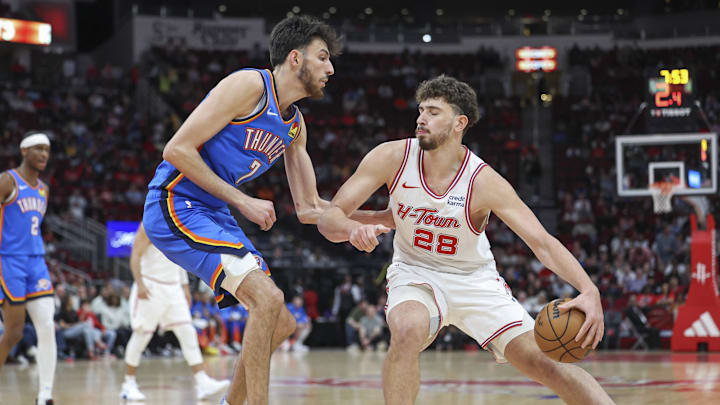 Feb 25, 2024; Houston, Texas, USA; Houston Rockets center Alperen Sengun (28) controls the ball as Oklahoma City Thunder forward Chet Holmgren (7) defends during the first quarter at Toyota Center. Mandatory Credit: Troy Taormina-Imagn Images