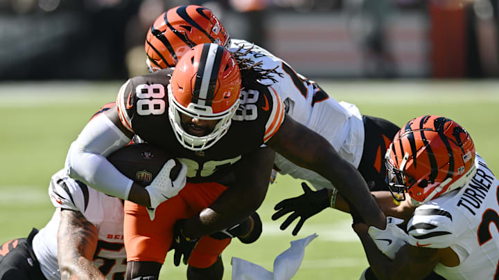 Oct 20, 2024; Cleveland, Ohio, USA; Cincinnati Bengals defensive tackle Justin Rogers (53) and linebacker Germaine Pratt (57) and cornerback DJ Turner II (20) tackle Cleveland Browns tight end Jordan Akins (88) during the first quarter at Huntington Bank Field. Mandatory Credit: Ken Blaze-Imagn Images