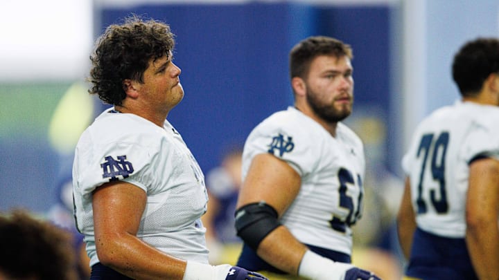Notre Dame offensive linemen Sullivan Absher, left, and Rocco Spindler (50), right, warm up during a Notre Dame football practice at Irish Athletic Center on Thursday, Aug. 15, 2024, in South Bend.
