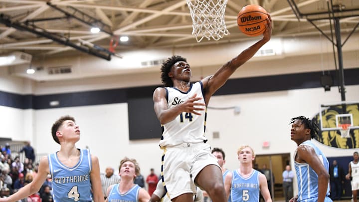 Feb 8, 2024; Tuscaloosa, Alabama, USA; Paul Bryant guard Adrian Wooley (14) goes to the basket over several Northridge defenders in the 6A Area Final at Paul W. Bryant High School. Bryant defeated Northridge 70-59 to claim the area title.