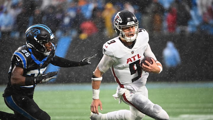 Dec 17, 2023; Charlotte, North Carolina, USA; Atlanta Falcons quarterback Desmond Ridder (9) runs as Carolina Panthers safety Xavier Woods (25) defends in the fourth quarter at Bank of America Stadium. Mandatory Credit: Bob Donnan-Imagn Images