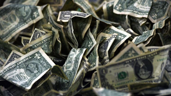 A pile of dollar bills sits on a table on Saturday, December 11, 2021.
