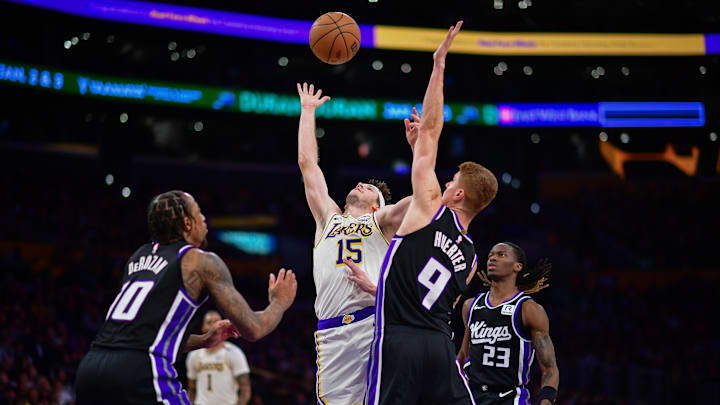 Dec 28, 2024; Los Angeles, California, USA; Los Angeles Lakers guard Austin Reaves (15) plays for the rebound against Sacramento Kings forward DeMar DeRozan (10) and guard Kevin Huerter (9) during the second half at Crypto.com Arena. Mandatory Credit: Gary A. Vasquez-Imagn Images
