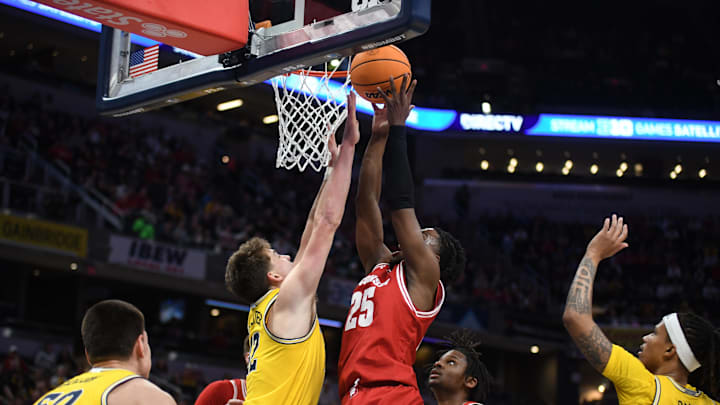 Mar 16, 2025; Indianapolis, IN, USA; Wisconsin Badgers guard John Blackwell (25) shoots a layup past Michigan Wolverines forward Will Tschetter (42) during the first half during the 2025 Big Ten Championship Game at Gainbridge Fieldhouse.