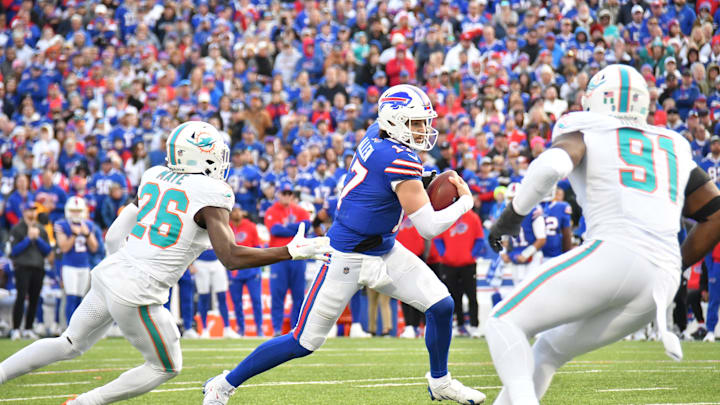 Buffalo Bills quarterback Josh Allen (17) runs between Miami Dolphins safety Marcus Maye (26) and linebacker Emmanuel Ogbah (91) in the fourth quarter at Highmark Stadium. Buffalo Bills quarterback Josh Allen (17) runs between Miami Dolphins safety Marcus Maye (26) and linebacker Emmanuel Ogbah (91) in the fourth quarter at Highmark Stadium.