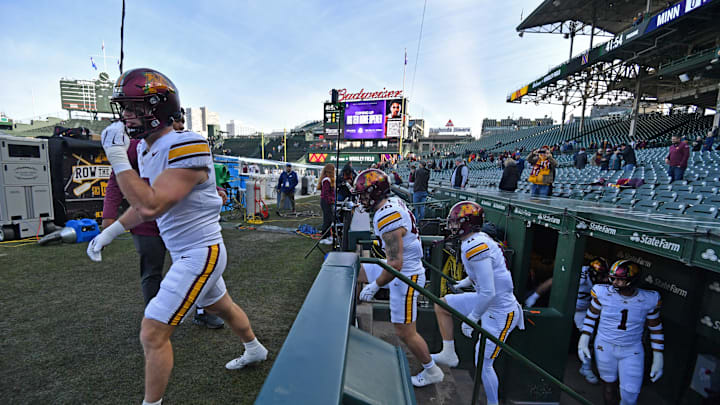 Nov 22, 2025; Chicago, Illinois, USA; The Minnesota Golden Gophers enter the field from the dugout prior to a game against the Northwestern Wildcats at Wrigley Field. Mandatory Credit: Patrick Gorski-Imagn Images