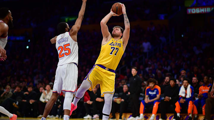 Mar 6, 2025; Los Angeles, California, USA; Los Angeles Lakers guard Luka Doncic (77) shoots against New York Knicks forward Mikal Bridges (25) during the second half at Crypto.com Arena. Mandatory Credit: Gary A. Vasquez-Imagn Images