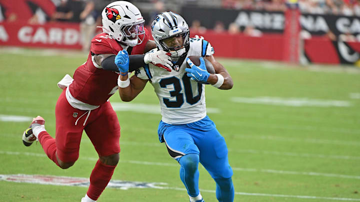 Sep 14, 2025; Glendale, Arizona, USA;  Carolina Panthers running back Chuba Hubbard (30) runs with the ball during the fourth quarter against Arizona Cardinals linebacker Mack Wilson Sr. (2)at State Farm Stadium. Mandatory Credit: Matt Kartozian-Imagn Images