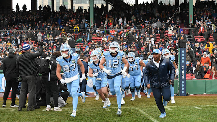 Dec 28, 2024; Boston, MA, USA; The North Carolina Tar Heels run onto the field before  the 2024 Fenway Bowl against the Connecticut Huskies at Fenway Park. Mandatory Credit: Eric Canha-Imagn Images