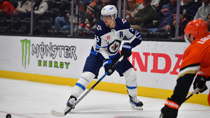 Dec 18, 2024; Anaheim, California, USA; Winnipeg Jets center Mark Scheifele (55) controls the puck against the Anaheim Ducks during the first period at Honda Center. Mandatory Credit: Gary A. Vasquez-Imagn Images