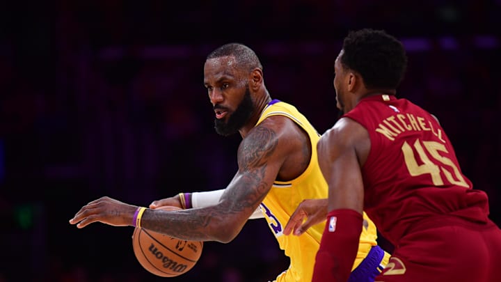 Dec 31, 2024; Los Angeles, California, USA; Los Angeles Lakers forward LeBron James (23) moves the ball against Cleveland Cavaliers guard Donovan Mitchell (45) during the first half at Crypto.com Arena. Mandatory Credit: Gary A. Vasquez-Imagn Images