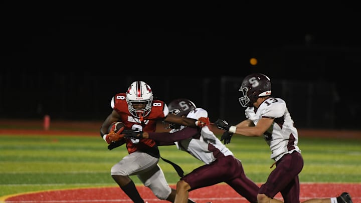 Two defenders attempt to tackle Lex Cyrus (8) during Shippensburg's game against Susquehanna Twp. on Thursday, September 21, 2023. The Greyhounds lost 28-19