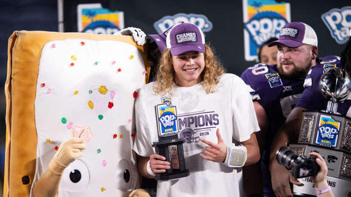 Dec 28, 2023; Orlando, FL, USA; Kansas State quarterback Avery Johnson (2) celebrates his MPV honors with the pop-tart mascot at Camping World Stadium. Mandatory Credit: Jeremy Reper-USA TODAY Sports Dec 28, 2023; Orlando, FL, USA; Kansas State quarterback Avery Johnson (2) celebrates his MPV honors with the pop-tart mascot at Camping World Stadium. Mandatory Credit: Jeremy Reper-USA TODAY Sports