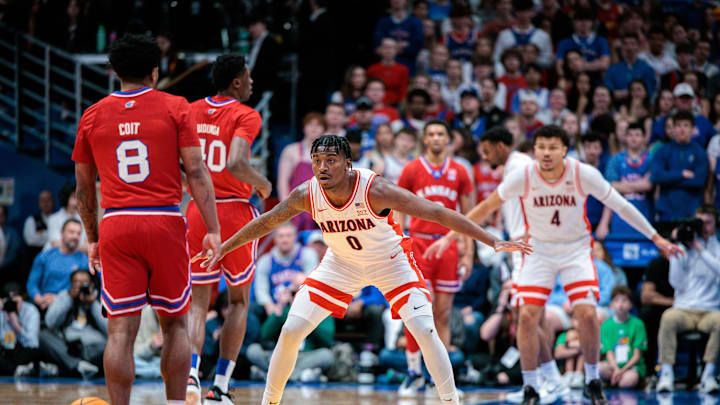 Mar 8, 2025; Lawrence, Kansas, USA; Arizona Wildcats guard Jaden Bradley (0) guards Kansas Jayhawks guard David Coit (8) during the first half at Allen Fieldhouse. Mandatory Credit: William Purnell-Imagn Images