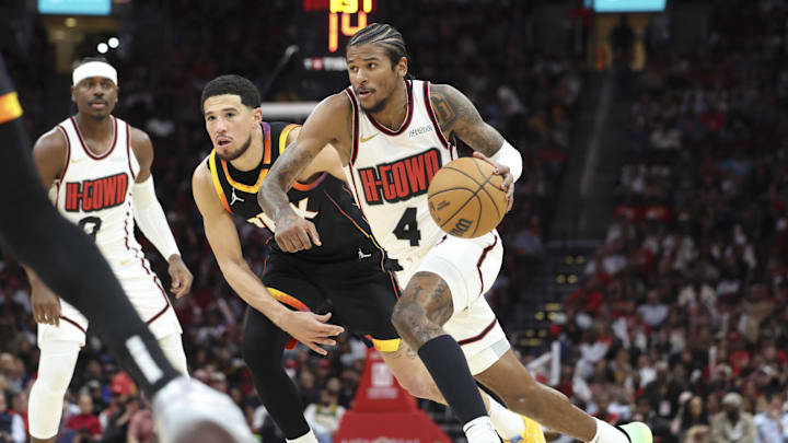 Mar 12, 2025; Houston, Texas, USA; Houston Rockets guard Jalen Green (4) drives with the ball as Phoenix Suns guard Devin Booker (1) defends during the third quarter at Toyota Center. Mandatory Credit: Troy Taormina-Imagn Images