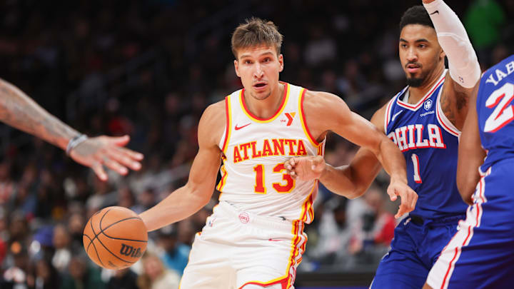 Oct 14, 2024; Atlanta, Georgia, USA; Atlanta Hawks guard Bogdan Bogdanovic (13) drives on Philadelphia 76ers forward KJ Martin (1) in the third quarter at State Farm Arena. Mandatory Credit: Brett Davis-Imagn Images
