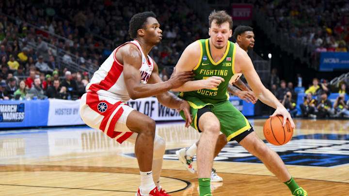 Mar 23, 2025; Seattle, WA, USA;  Oregon Ducks center Nate Bittle (32) dribbles the ball against Arizona Wildcats forward Tobe Awaka (30) in the first half at Climate Pledge Arena. Mandatory Credit: Steven Bisig-Imagn Images
