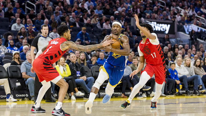 Mar 10, 2025; San Francisco, California, USA; Golden State Warriors forward Jimmy Butler III (10) drives past Portland Trail Blazers guard Shaedon Sharpe (17) and guard Anfernee Simons (1) during the second quarter at Chase Center. Mandatory Credit: John Hefti-Imagn Images