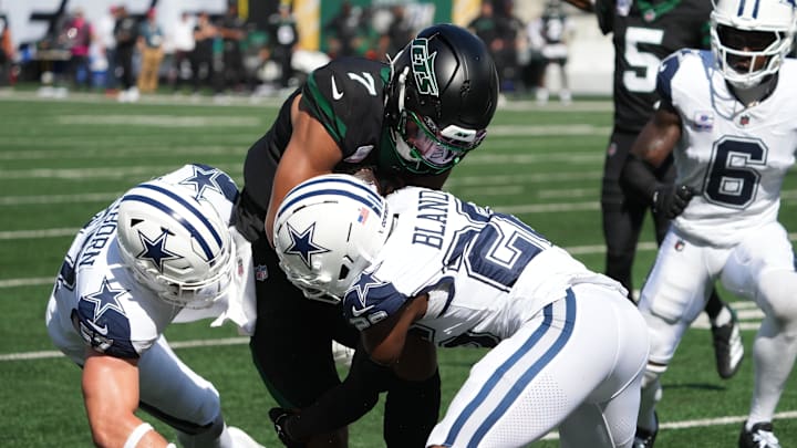 Oct 5, 2025; East Rutherford, New Jersey, USA; New York Jets quarterback Justin Fields (7) is tackled by Dallas Cowboys linebacker Jack Sanborn (57) and cornerback Daron Bland (26) during the first half at MetLife Stadium. Mandatory Credit: Robert Deutsch-Imagn Images