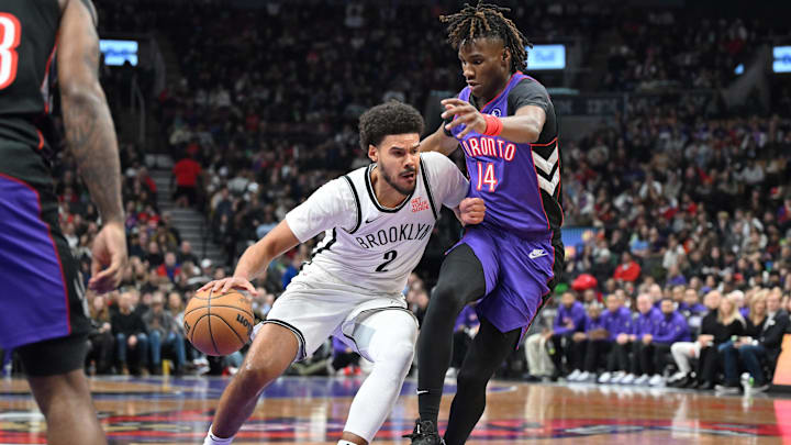 Dec 19, 2024; Toronto, Ontario, CAN;  Brooklyn Nets forward Cam Johnson (2) dribbles the ball past Toronto Raptors guard Ja'Kobe Walter (14) in the first half at Scotiabank Arena. Mandatory Credit: Dan Hamilton-Imagn Images