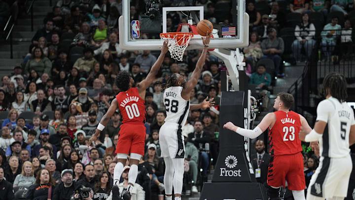 Dec 21, 2024; San Antonio, Texas, USA;  San Antonio Spurs center Charles Bassey (28) shoots the ball against Portland Trail Blazers guard Scoot Henderson (00) in the first half at Frost Bank Center. `