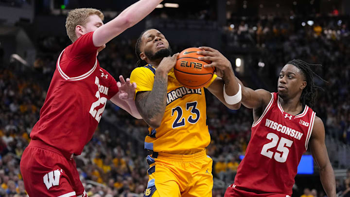 Dec 7, 2024; Milwaukee, Wisconsin, USA;  Marquette Golden Eagles forward David Joplin (23) drives for the basket between Wisconsin Badgers forward Steven Crowl (22) and guard John Blackwell (25) during the second half at Fiserv Forum. Mandatory Credit: Jeff Hanisch-Imagn Images