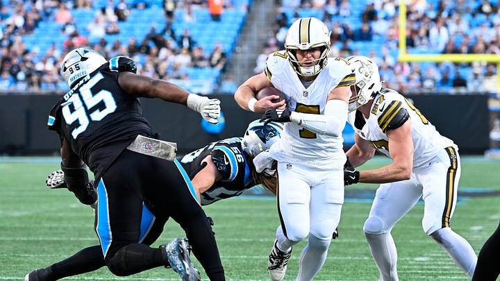 Nov 9, 2025; Charlotte, North Carolina, USA; New Orleans Saints quarterback Taysom Hill (7) rushes during the fourth quarter as Carolina Panthers defensive end Derrick Brown (95) defends at Bank of America Stadium. Mandatory Credit: Bob Donnan-Imagn Images