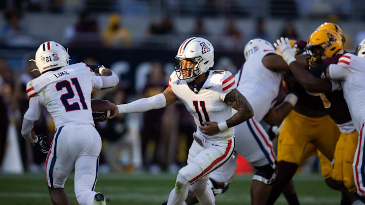 Nov 25, 2023; Tempe, Arizona, USA; Arizona Wildcats quarterback Noah Fifita (11) hands the ball off to running back Rayshon Luke (21) against the Arizona State Sun Devils in the Territorial Cup at Mountain America Stadium. Mandatory Credit: Mark J. Rebilas-USA TODAY Sports