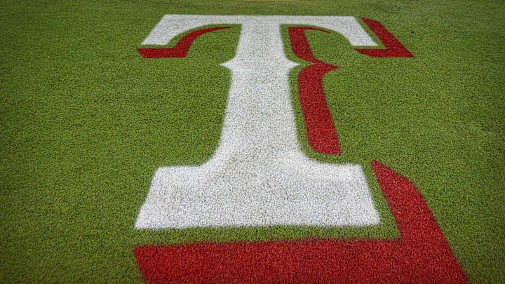The Texas Rangers logo painted on the turf behind home plate at Globe Life Field in Arlington, Texas.