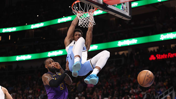 Dec 6, 2024; Atlanta, Georgia, USA; Atlanta Hawks forward De'Andre Hunter (12) dunks past Los Angeles Lakers forward LeBron James (23) in overtime at State Farm Arena. Mandatory Credit: Brett Davis-Imagn Images

