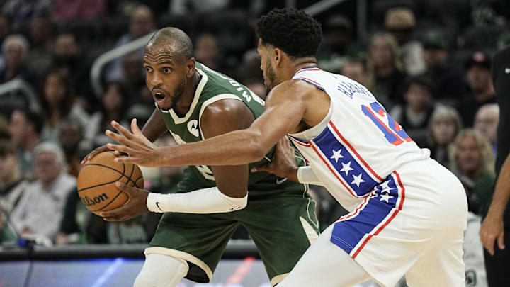 Oct 26, 2023; Milwaukee, Wisconsin, USA;  Milwaukee Bucks forward Khris Middleton (22) holds the ball away from Philadelphia 76ers forward Tobias Harris (12) during the first quarter at Fiserv Forum. Mandatory Credit: Jeff Hanisch-Imagn Images
