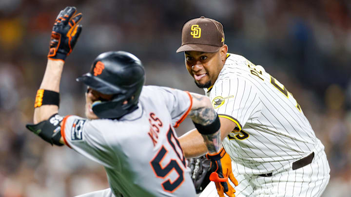 Aug 18, 2025; San Diego, California, USA; San Diego Padres relief pitcher Wandy Peralta (58) chases down San Francisco Giants second baseman Christian Koss (50) for an out during the eighth inning against the San Francisco Giants at Petco Park.