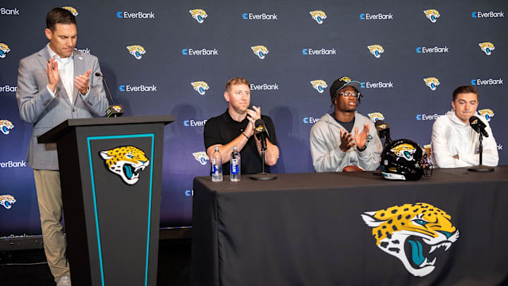 John Dever, Senior Vice President and Chief Communications Officer for the Jacksonville Jaguars, left, claps after introducing the Jacksonville Jaguars’ first-round pick, Colorado Buffaloes wide receiver and defensive back Travis Hunter, third from left, before answering questions during a press conference Friday, March 25, 2025 at Miller Electric Center in Jacksonville, Fla. with Head Coach Liam Coen, second from left and General Manager James Gladstone, right. [Doug Engle/Florida Times-Union]