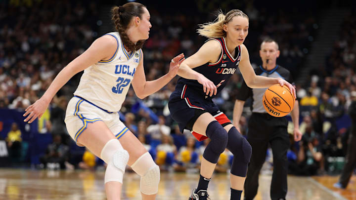 Apr 4, 2025; Tampa, FL, USA; Connecticut Huskies guard Paige Bueckers (5) dribbles against UCLA Bruins forward Angela Dugalic (32) during the third quarter in a semifinal of the women's 2025 NCAA tournament at Amalie Arena. Mandatory Credit: Nathan Ray Seebeck-Imagn Images Apr 4, 2025; Tampa, FL, USA; Connecticut Huskies guard Paige Bueckers (5) dribbles against UCLA Bruins forward Angela Dugalic (32) during the third quarter in a semifinal of the women's 2025 NCAA tournament at Amalie Arena. Mandatory Credit: Nathan Ray Seebeck-Imagn Images