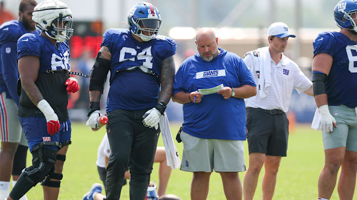 Aug 4, 2025; East Rutherford, NJ, USA; New York Giants offensive line coach Carmen Bricillo talks with guard Aaron Stinnie (64) during training camp at Quest Diagnostics Training Center.  