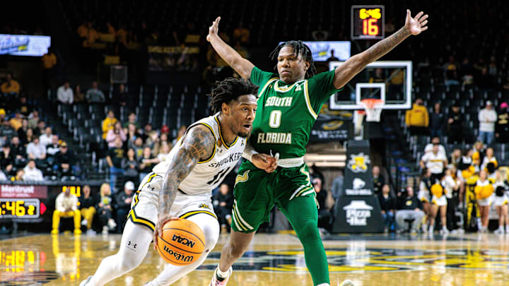  Wichita State Shockers guard Justin Hill (11) drives around South Florida Bulls guard Jayden Reid (0) during the second half at Charles Koch Arena. Mandatory Credit: William Purnell-Imagn Images