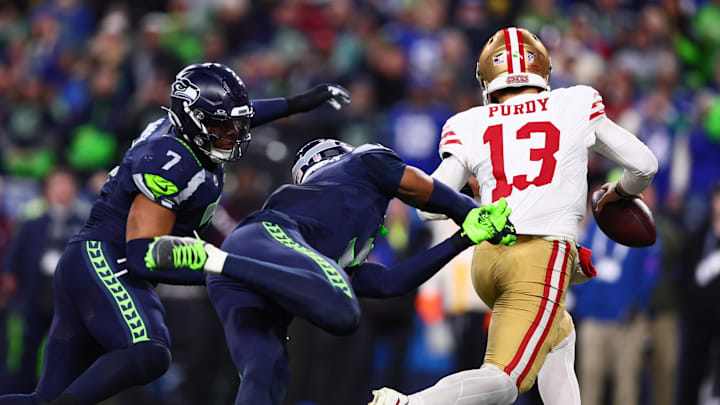 Jan 17, 2026; Seattle, WA, USA; San Francisco 49ers quarterback Brock Purdy (13) is pressured by the Seattle Seahawks defense during the second half in an NFC Divisional Round game at Lumen Field. Mandatory Credit: Kevin Ng-Imagn Images