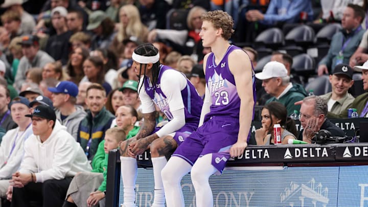 Mar 17, 2025; Salt Lake City, Utah, USA;  Utah Jazz guard Jordan Clarkson (00) and forward Lauri Markkanen (23) sit not he scorers table during the second quarter against the Chicago Bulls at Delta Center. Mandatory Credit: Chris Nicoll-Imagn Images