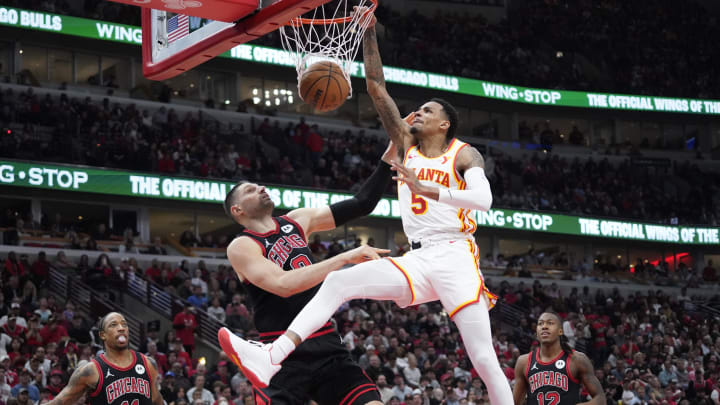 Apr 17, 2024; Chicago, Illinois, USA; Atlanta Hawks guard Dejounte Murray (5) dunks the ball on Chicago Bulls center Nikola Vucevic (9) during the second half during a play-in game of the 2024 NBA playoffs at United Center. Apr 17, 2024; Chicago, Illinois, USA; Atlanta Hawks guard Dejounte Murray (5) dunks the ball on Chicago Bulls center Nikola Vucevic (9) during the second half during a play-in game of the 2024 NBA playoffs at United Center.