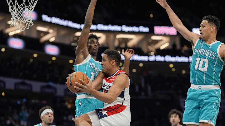 Feb 3, 2025; Charlotte, North Carolina, USA; Washington Wizards guard Malcolm Brogdon (15) at the rim defended by Charlotte Hornets forward Moussa Diabate (14) during the second half at Spectrum Center. Mandatory Credit: Jim Dedmon-Imagn Images