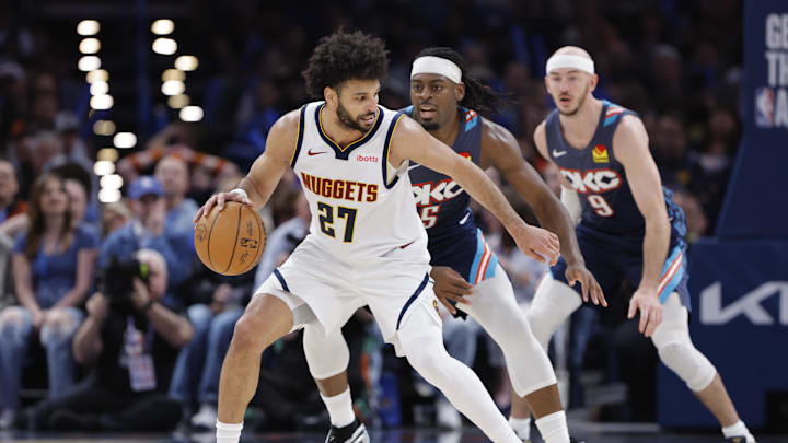 Feb 27, 2026; Oklahoma City, Oklahoma, USA; Denver Nuggets guard Jamal Murray (27) moves the ball around Oklahoma City Thunder guard Luguentz Dort (5) during the third quarter at Paycom Center. Mandatory Credit: Alonzo Adams-Imagn Images