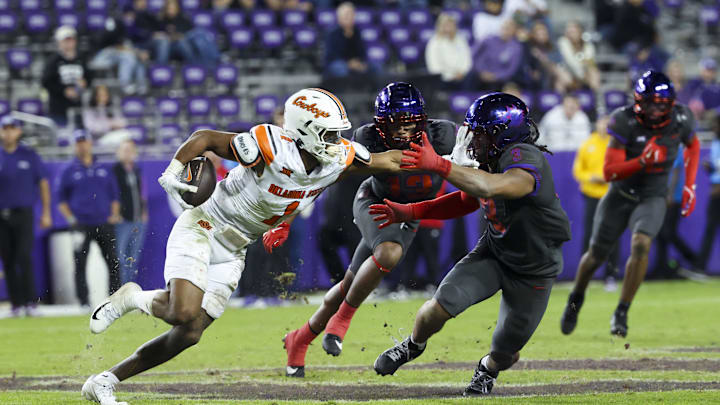 Nov 9, 2024; Fort Worth, Texas, USA;  Oklahoma State Cowboys wide receiver De'Zhaun Stribling (1) stiff arms TCU Horned Frogs linebacker Kaleb Elarms-Orr (3) during the second half at Amon G. Carter Stadium. Mandatory Credit: Kevin Jairaj-Imagn Images