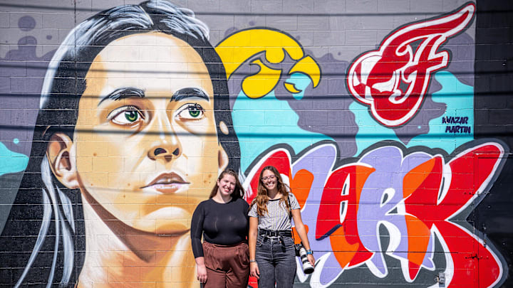 IndyStar’s Indiana Fever reporter Chloe Peterson and staff photographer Grace Smith pose Tuesday, Sept. 17, 2024, in front of a Caitlin Clark mural by Indianapolis artist Kwazar Martin. Peterson and Smith, both former University of Iowa students, covered Clark’s basketball journey through college. Both now cover Clark as a professional WNBA player for the Indiana Fever. IndyStar’s Indiana Fever reporter Chloe Peterson and staff photographer Grace Smith pose Tuesday, Sept. 17, 2024, in front of a Caitlin Clark mural by Indianapolis artist Kwazar Martin. Peterson and Smith, both former University of Iowa students, covered Clark’s basketball journey through college. Both now cover Clark as a professional WNBA player for the Indiana Fever.
